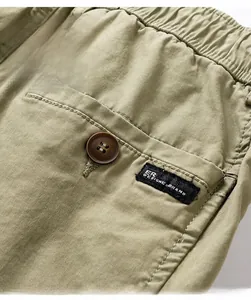 Detail of army green cargo shorts with elastic waist and back pocket with button