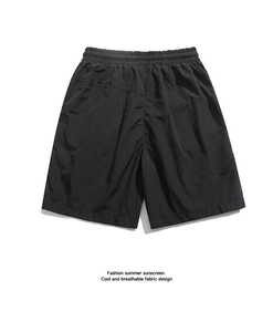 Detail view of men's black quick-dry shorts featuring an elastic waistband and breathable fabric