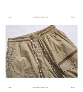 Detail of khaki cargo shorts featuring elastic waistband and braided drawstring cord