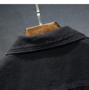 Dettaglio ravvicinato di colletto e spalla di una giacca di jeans nera con doppie cuciture