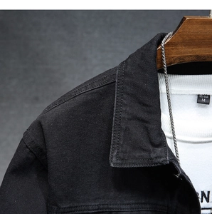 Dettaglio della giacca di jeans nera con trama in saia fine e doppia cucitura