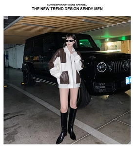 Dettaglio giacca patchwork con tasche in pelle marrone e stile alla moda street