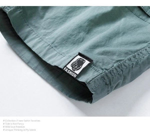 Close-up of dual-needle stitching and fashion patch on cotton cargo shorts