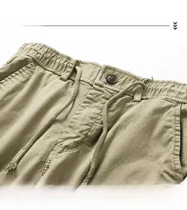 Detail view of khaki cotton twill shorts with elastic waist, drawstring and button closure