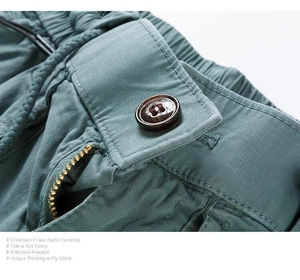Detailed macro view of elastic waistband with resin button and metal zipper on cargo shorts