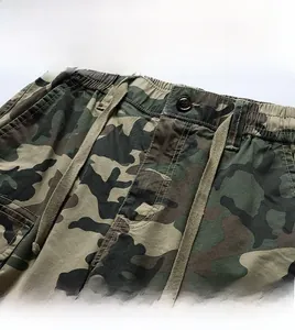 Detail of camouflage pants waistband with elastic waist, drawstring and button closure