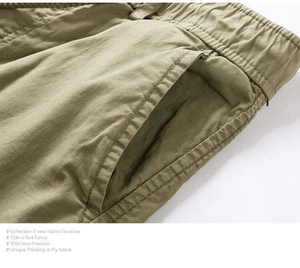 Detail of khaki cotton twill shorts featuring elastic drawstring waist and side pockets