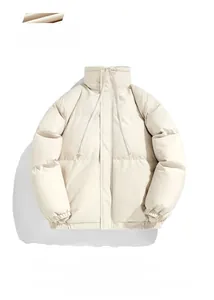 Detail of beige oversized puffer jacket showing quilted texture and drawstring stand collar