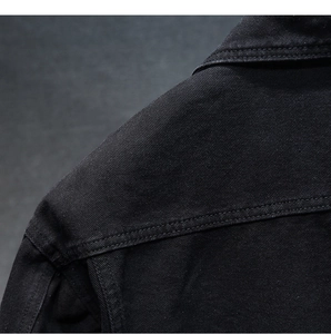 Dettaglio cuciture spalla giacca denim nera con trama di tessuto twill ad alta densità
