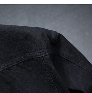 Dettaglio ravvicinato di denim nero antracite pesante con cuciture doppie robuste