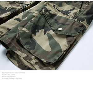 Detail of cargo pocket on camouflage trousers with metal snap button and cotton twill texture
