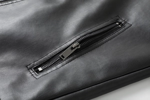 Close-up of premium black leather jacket showing high-quality metal zipper and stitching