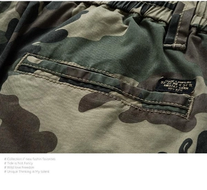 Macro detail of jungle camouflage cargo shorts with durable canvas texture and woven label