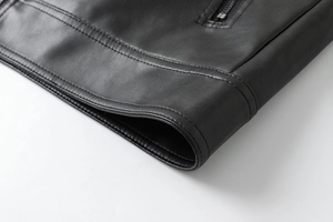 Detailed macro view of the black PU leather jacket hem with precise double stitching