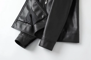 Close-up of smooth metal zipper and reinforced stitching on black PU leather jacket