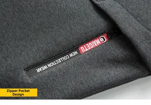 Detailed close-up of dark grey hoodie with a red zipper pocket and brand logo text