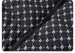 Detail of waterproof puffer jacket fabric featuring white B-letter and star monogram pattern