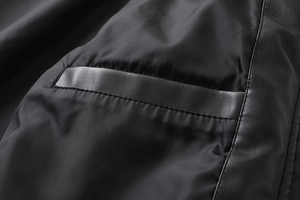 Detailed macro view of the inner pocket with leather trim on a black biker jacket