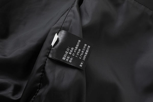 Detailed view of inner lining fabric composition and care label on men's PU jacket