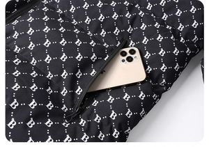 Detail of windproof puffer jacket pocket with B-letter print and smartphone storage