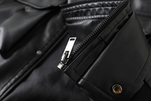 Macro shot of silver metal zipper and premium leather texture on black motor jacket