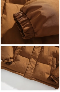 Detail view of elastic cuffs and windproof hidden zipper on brown puffer jacket