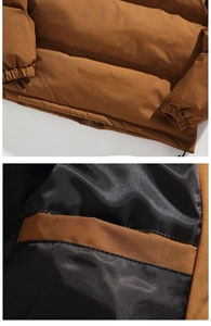 Detail view of the brown puffer jacket showing fine stitching and smooth black inner lining