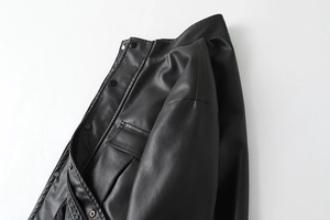 Close-up of black PU leather jacket showing collar details and functional chest pockets