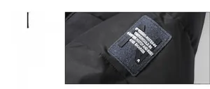 Close-up of windproof black jacket sleeve with blue felt brand patch and letter embroidery