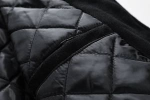 Detail of black quilted diamond lining and warm fleece trim on men's baseball jacket