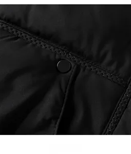 Detailansicht eines mattschwarzen Druckknopfs und Steppnähte an der Winterjacke