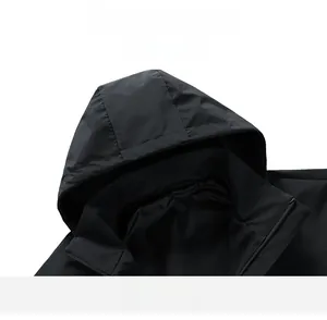 Detail view of black hooded jacket featuring windproof nylon fabric and premium zipper closure