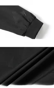 Detail of black baseball jacket featuring ribbed cuffs and geometric pattern fabric