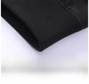 Close-up of black ribbed knit cuffs and hem showing high-quality stitching on bomber jacket