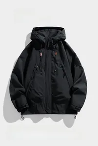 Detalle de chaqueta negra con capucha para exterior con puños ajustables y bolsillos con cremallera