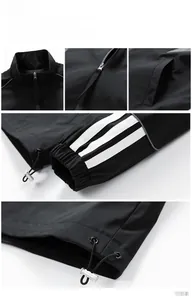 Detail of black stand-collar jacket featuring signature white stripes and adjustable hem