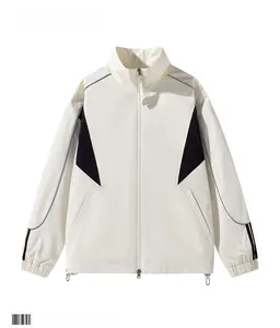 Detail view of cream stand-collar jacket featuring black geometric contrast panels and hem cords