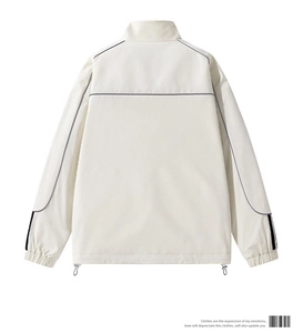 Detail of off-white stand collar jacket featuring grey piped back seams and elastic cuffs