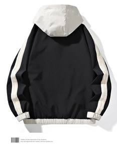 Detail of a men's windbreaker jacket with contrast white panels on black fabric