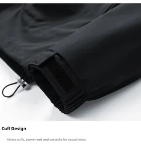 Detalle de puños de velcro ajustables y cordón elástico en la chaqueta negra