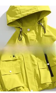 Detail view of lime green jacket collar zipper and cargo pocket design