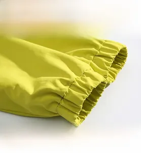 Detail view of the elastic cuffs and large utility pockets on the yellow outdoor jacket