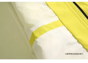 Detail of waterproof outdoor jacket showing yellow and white color-block fabric with zipper