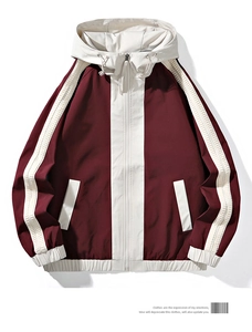 Detailed flat lay of a burgundy and beige hooded windbreaker with zip-up design