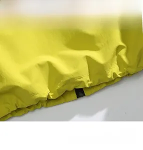 Detail of the bright yellow waterproof jacket showing interior zipper pocket and drawstring hem