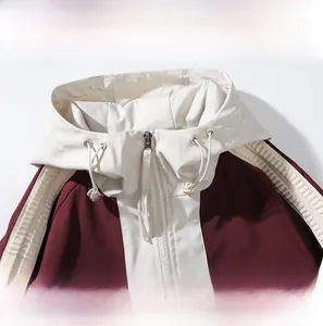 Detail of burgundy hooded jacket featuring contrast beige lining and adjustable drawstrings