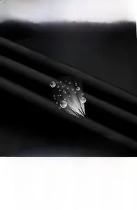 Detail of stain-resistant tech fabric with water droplets on men's jacket surface