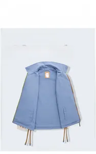 Detail view of smog blue reversible windbreaker featuring a stand collar and drawstring hem