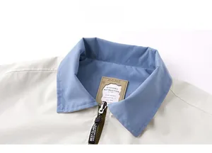 Detail of contrast blue collar and Best Classic zipper tape on casual beige jacket