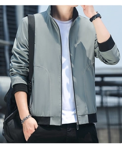 Detail of light grey-green casual jacket with ribbed collar and metal zipper pockets